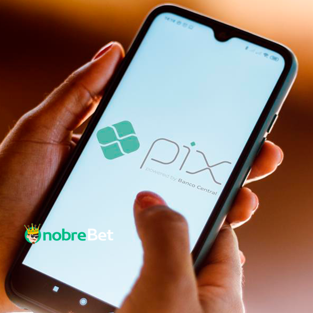 Mão segurando celular com logo PIX: Jogo que paga de verdade no PIX